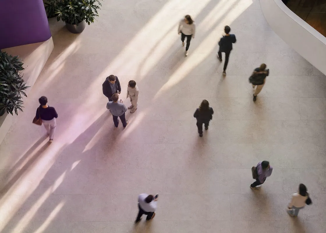 Overhead view of an office atrium where employees appear as movement patterns, not identifiable individuals